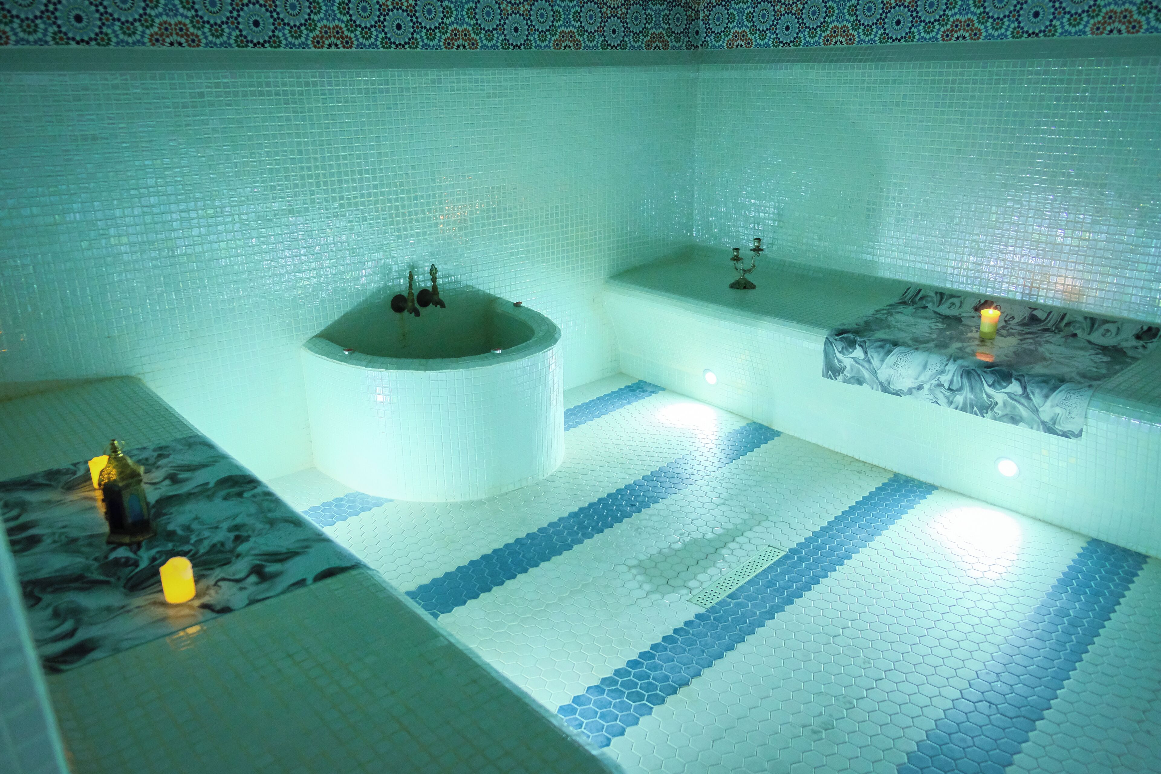 A bathroom with a large bathtub, a smaller tub, and a marble-topped vanity.