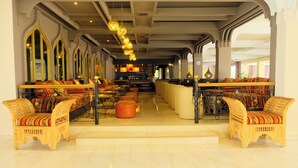 A spacious hotel lobby with high ceilings, ornate chandeliers, and traditional wooden furniture.