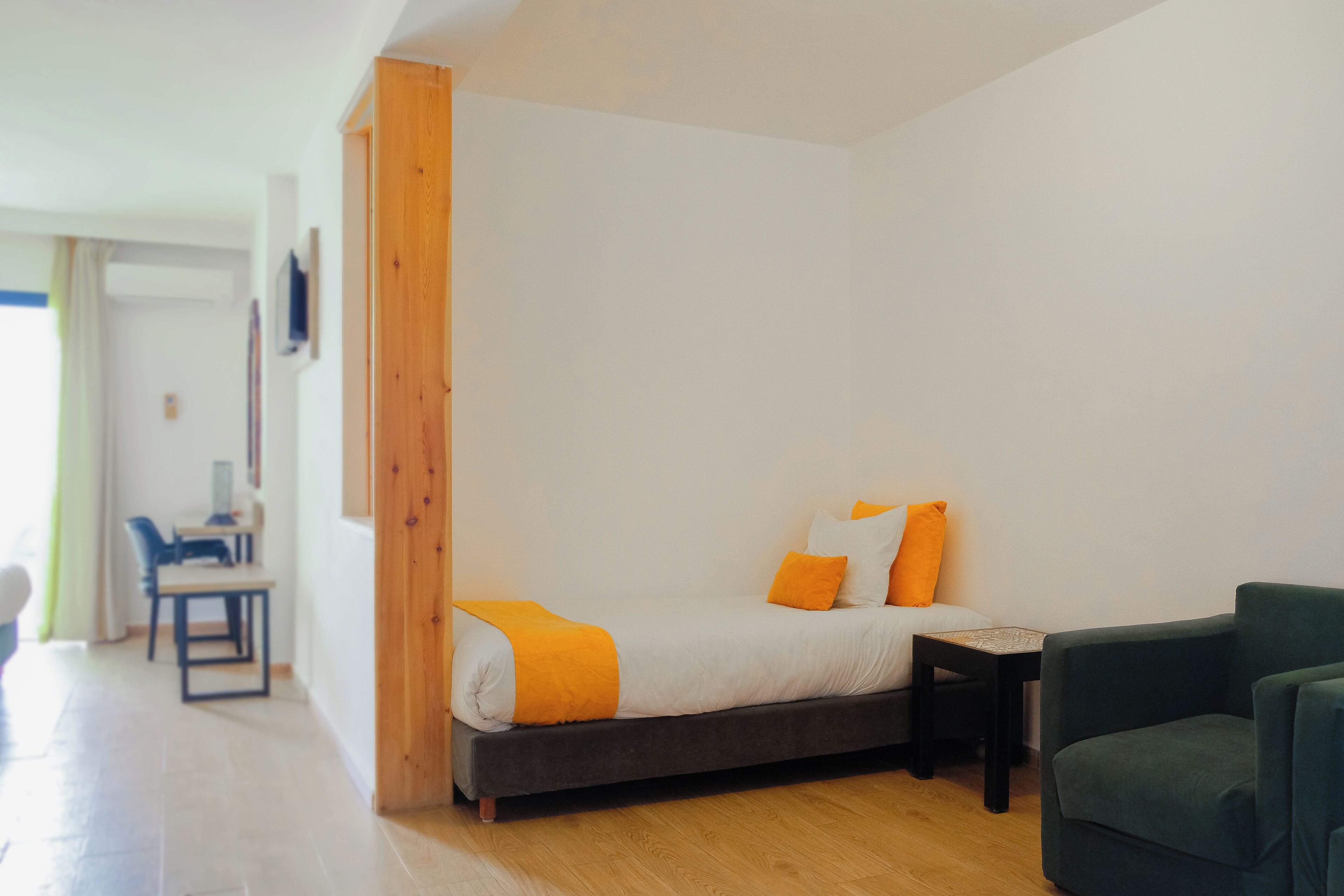 Un dormitorio moderno con una cama, un escritorio y una silla.