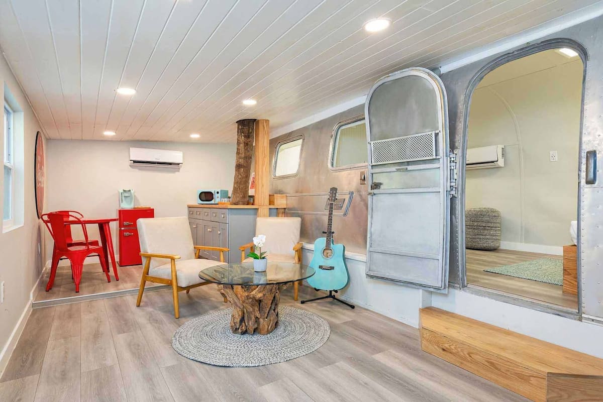 A compact living space with a dining area, a small kitchenette, and a sleeping area.