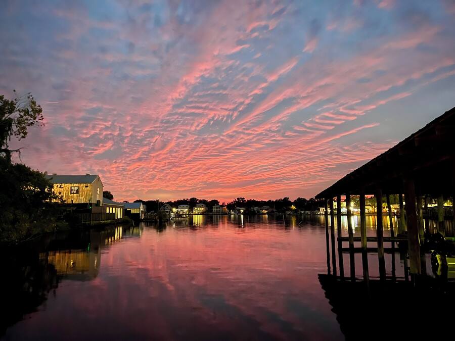 A waterfront scene with a calm lake reflecting the sky.