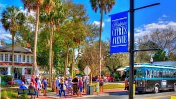 Zona histórica del centro con un letrero de Paisaje Histórico azul, una calle con peatones y un autobús.