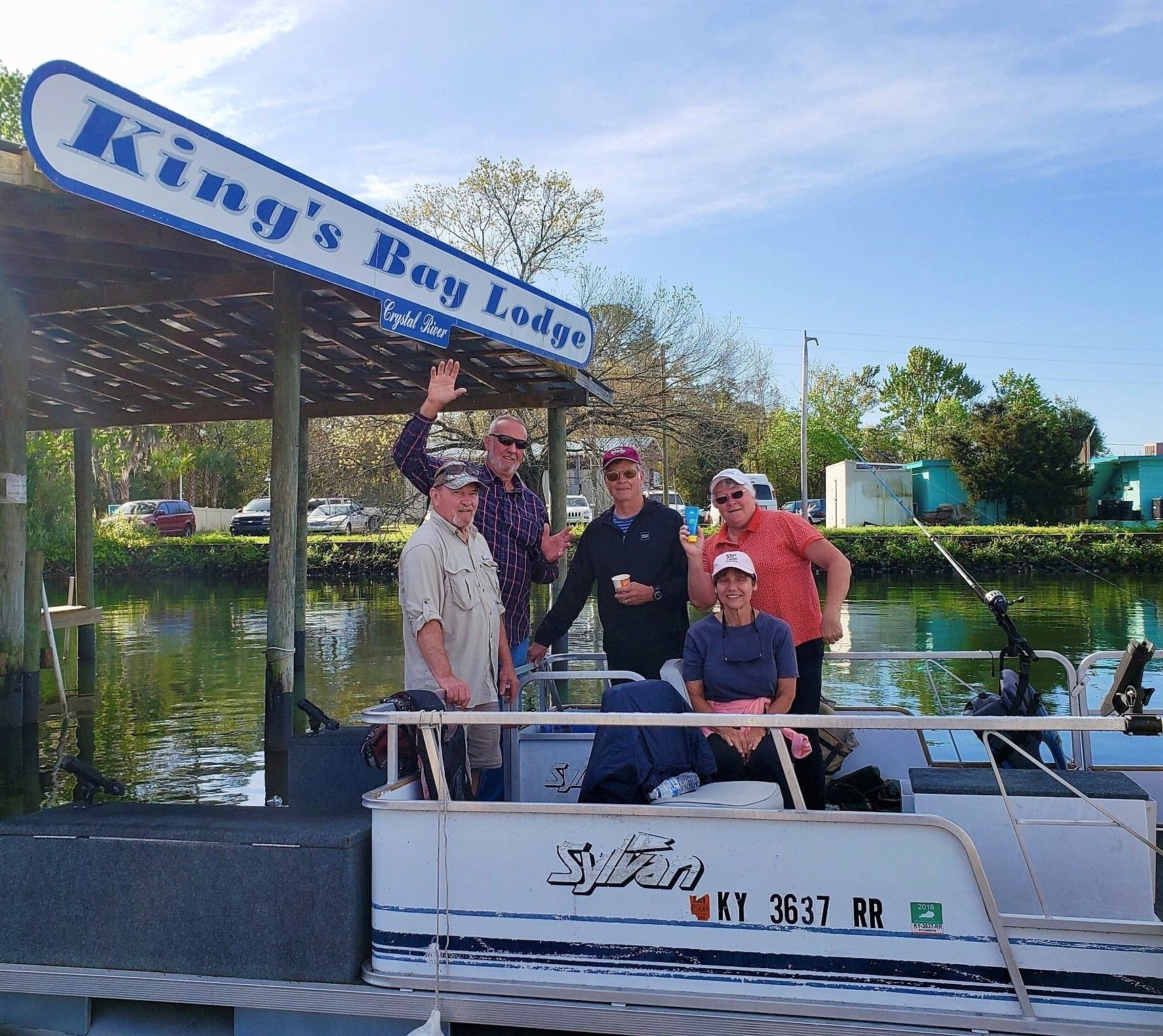 Un grupo de personas en un bote con un letrero que dice 'King's Bay Lodge' y un número de bote 'KY 3637 RR'.