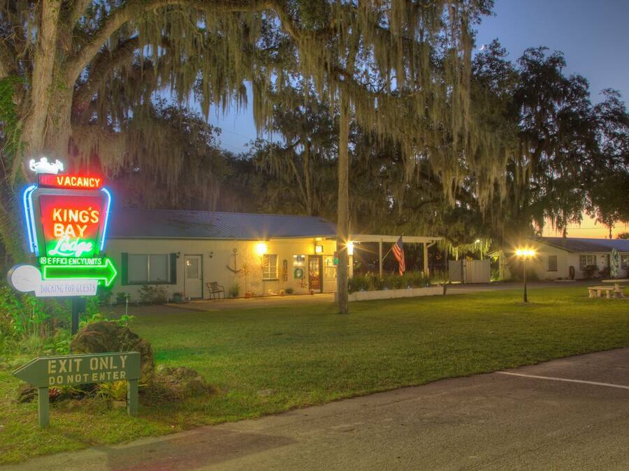 A motel named 'King's Bay' with a neon sign indicating vacancy and a 'Do Not Enter' sign.