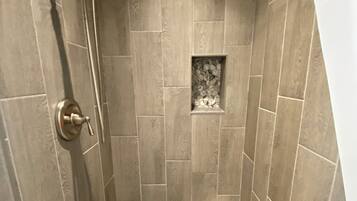 Een douche met een handdouche en een vaste douchekop.