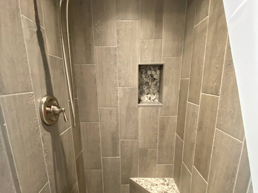 Een douche met een handdouche en een vaste douchekop.