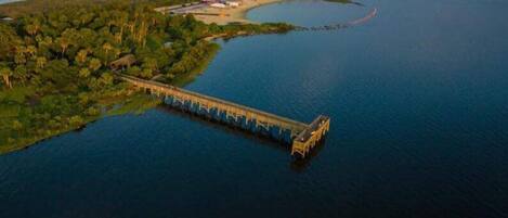 An aerial view of a bridge connecting two land masses over a large body of water.