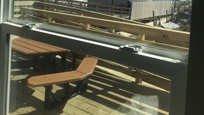 A view from a window overlooking a beach with a wooden bench and a fence. - Seaview Pier and Motel (Sneads Ferry)