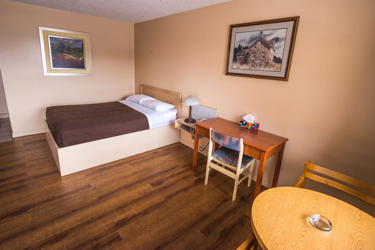 Una habitación de hotel con cama, escritorio, silla y mesa.