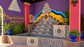 Una escalera conduce a la entrada de un motel, con un letrero que dice 'Baja del Sol Inn MOTEL'.