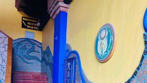 A staircase with red steps and blue accents, leading to a room with a mosaic wall and a decorative plate. - Hotel Baja del Sol Inn (Playas de Rosarito)