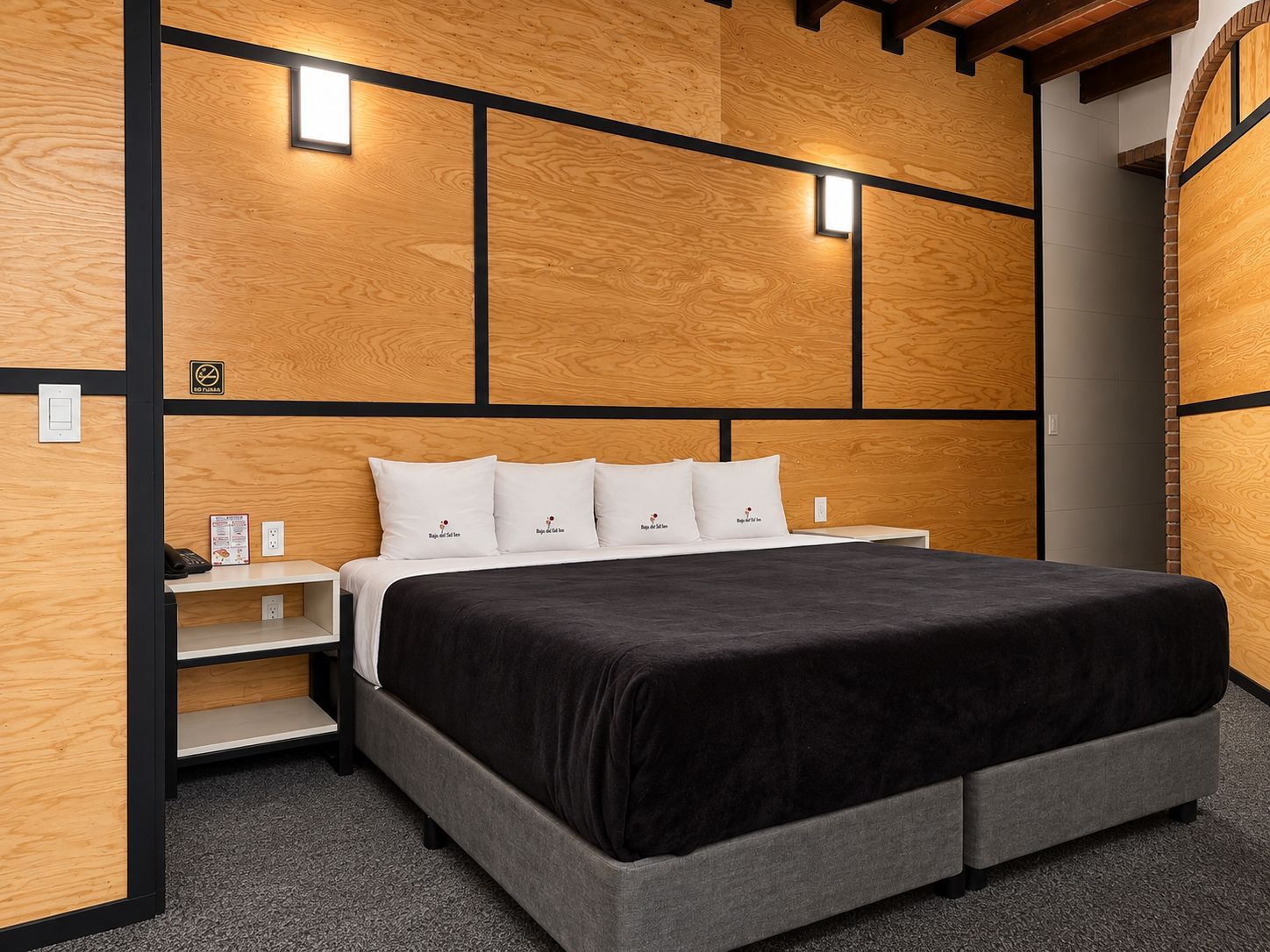 Un dormitorio moderno con una cama grande, paneles de madera y luces empotradas.