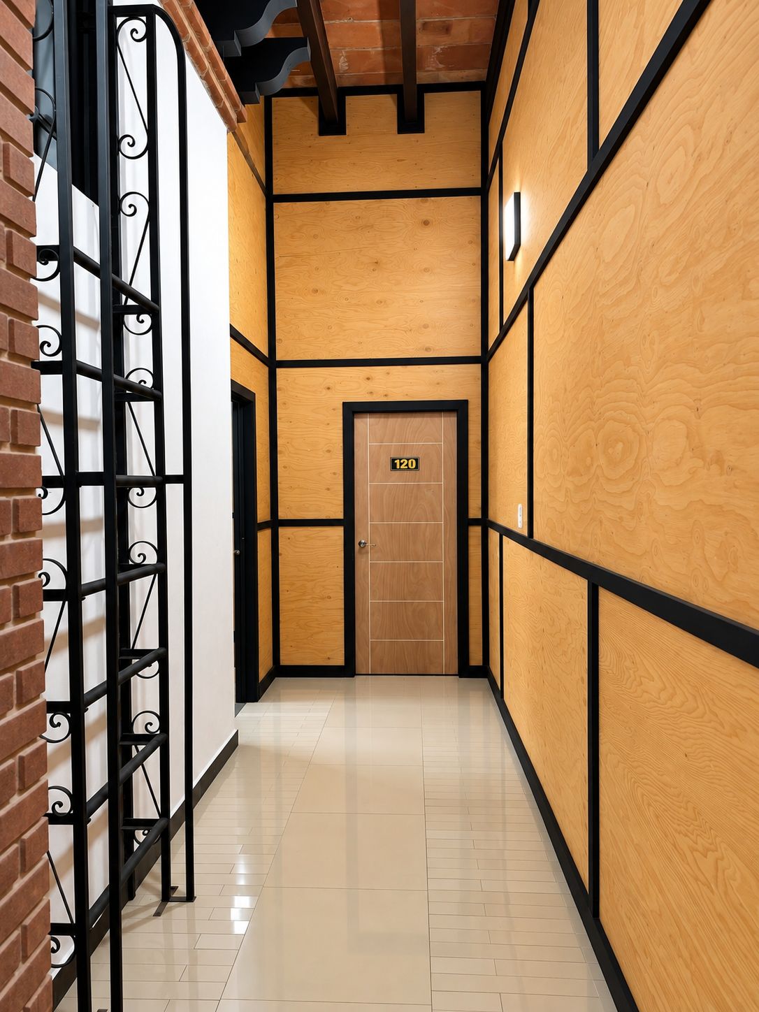 Un pasillo con una puerta de madera marcada '120' y una reja metálica a la izquierda.