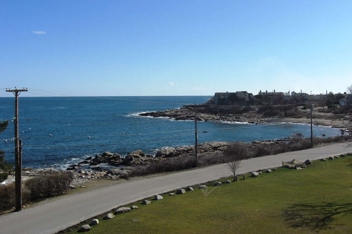 A coastal road with a clear view of the sea and rocky shoreline.
