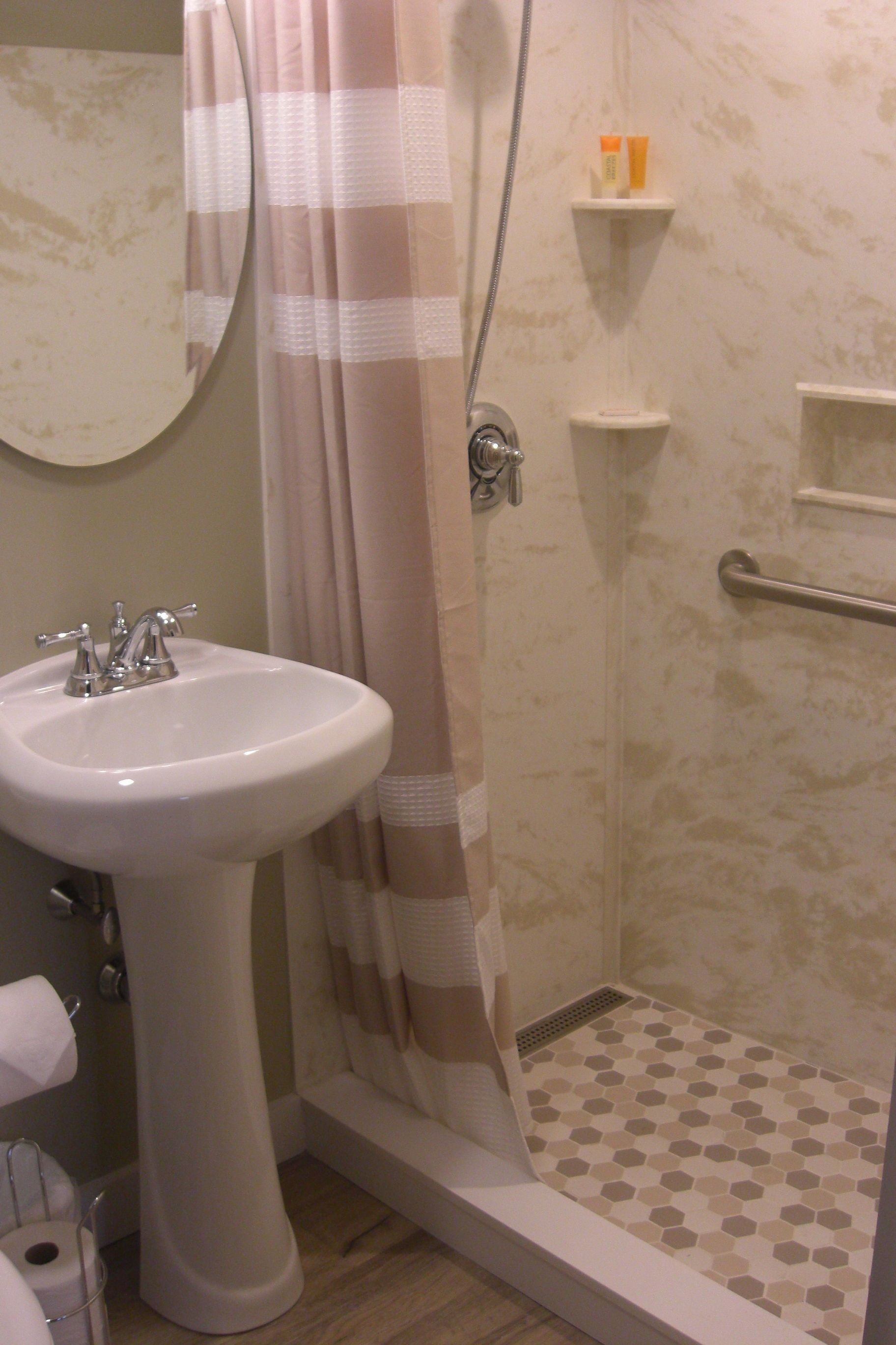 A bathroom with a sink, shower, and toilet.