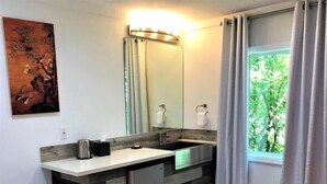Un baño moderno con un espejo grande, un lavabo y un inodoro.