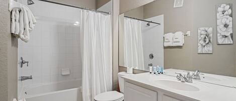 A modern bathroom with a bathtub, toilet, and sink.