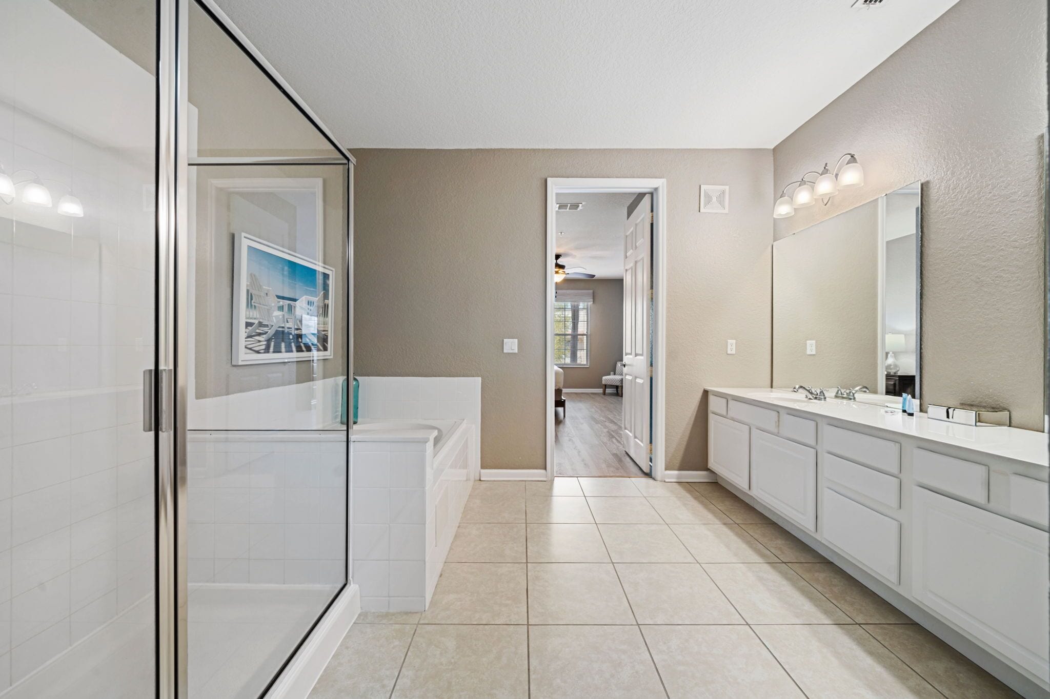 A modern bathroom with a glass shower enclosure, a large mirror, and a walk-in shower.
