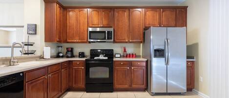 Una cocina moderna con armarios de madera, electrodomésticos de acero inoxidable y lavavajillas.