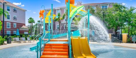 Parque acuático con tobogán, escaleras y una fuente de agua.