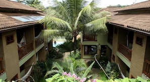 Surrounded by lush tropical plants, this hotel features a central courtyard with a swimming pool and balconies.