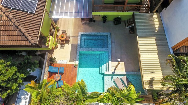A rooftop pool with a small seating area and a staircase leading to the pool. - Pousada Abaré (Itacaré)