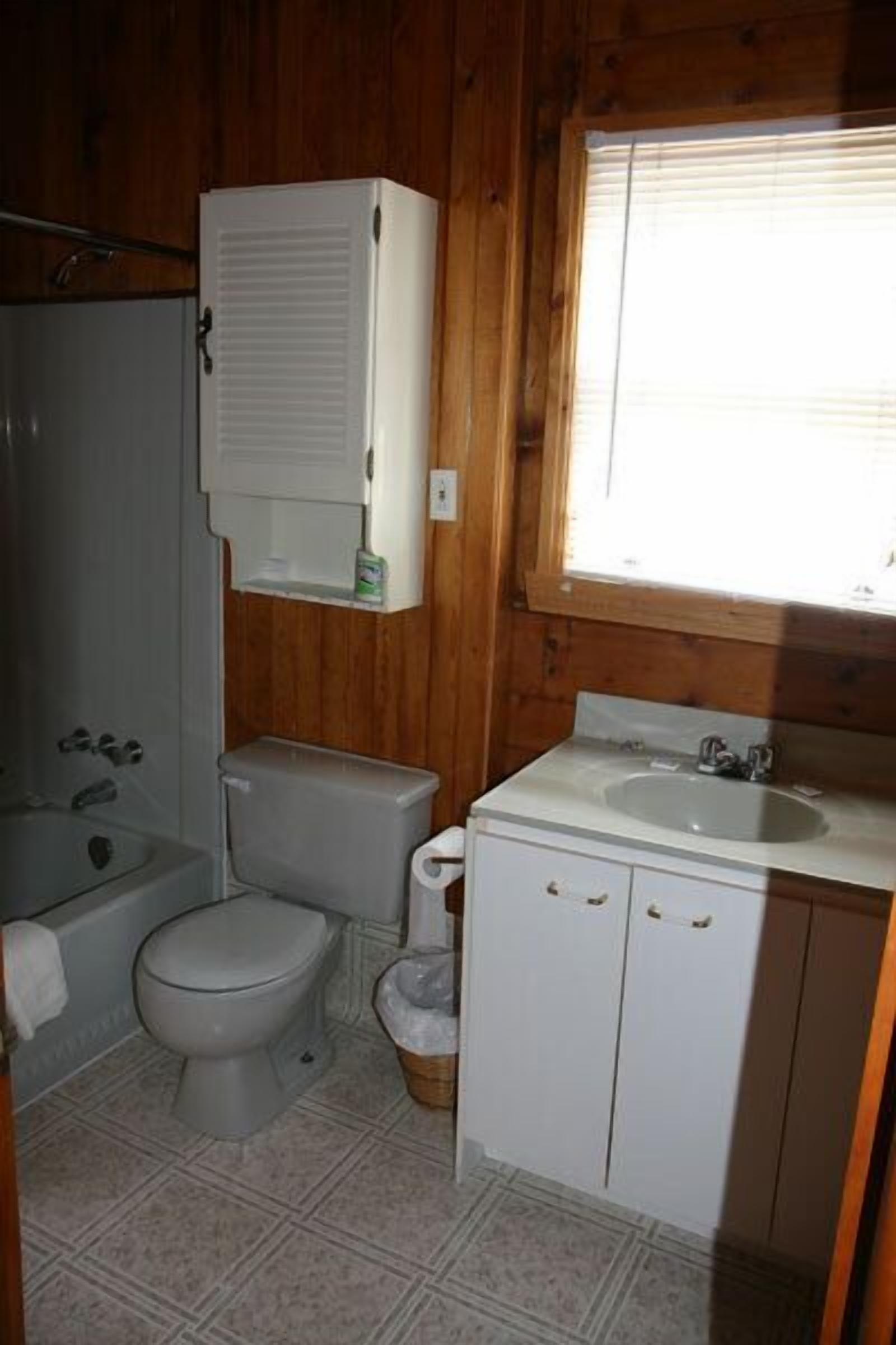 A small, compact bathroom with a toilet, sink, and shower.