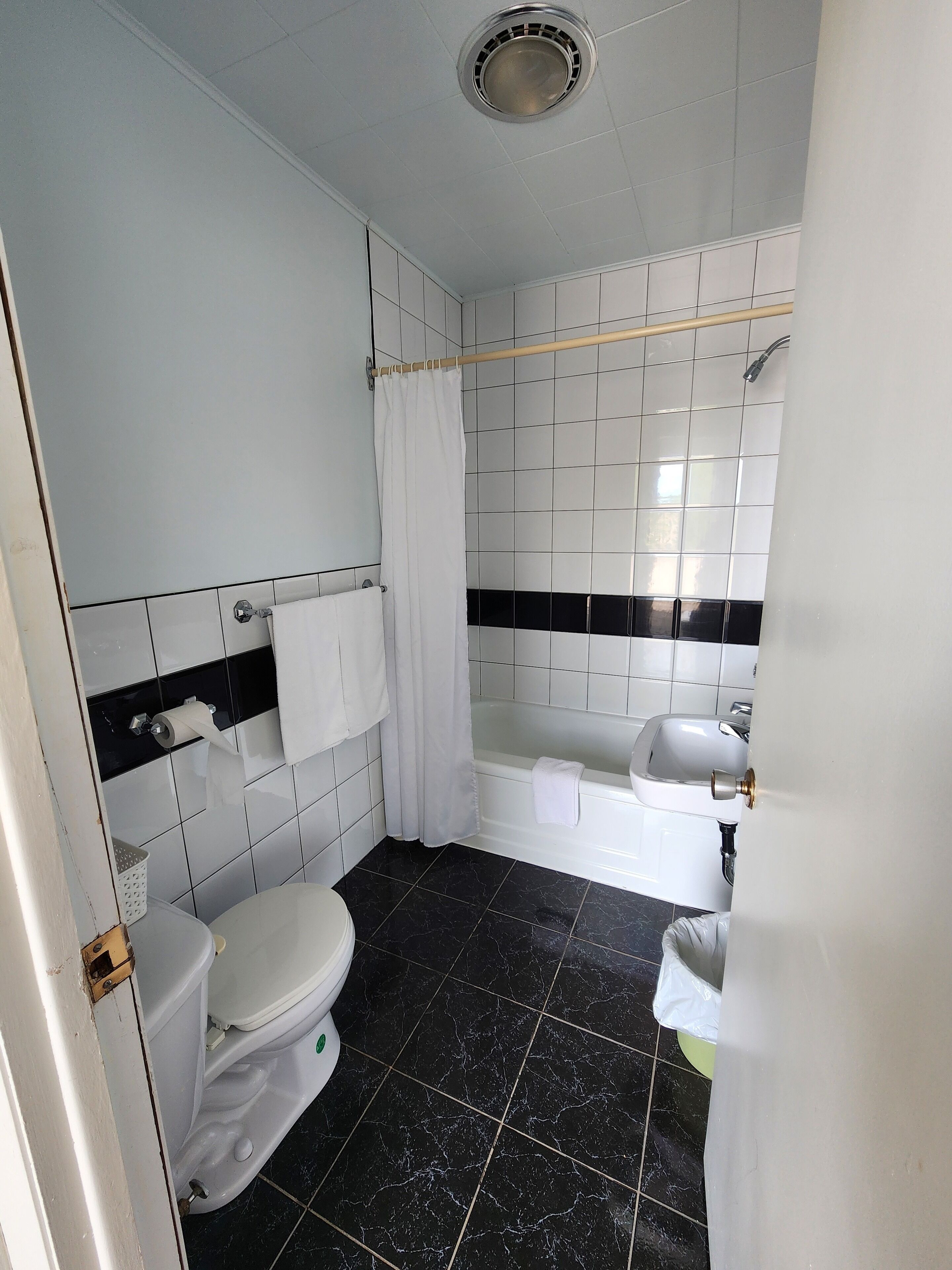 A bathroom with a toilet, a bathtub, a sink, and a shower.