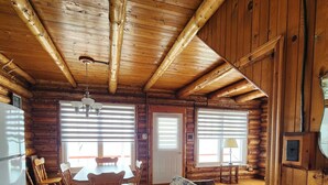 Ein Holzhaus-Interieur mit Essbereich, Küche und einem großen Fenster.