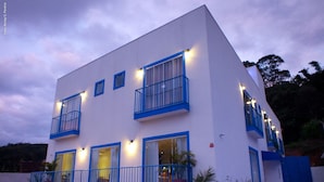 A modern two-story building with balconies, large windows, and outdoor lighting. - The Hyperion Boutique Hotel (Florianópolis)