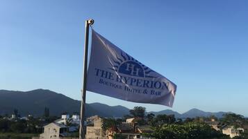 Una bandera con el texto "The Hyperion Boutique Hotel & Bar" y un emblema de sol.