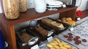 A buffet with various food items including bread, pastries, and a coffee station. - The Hyperion Boutique Hotel (Florianópolis)