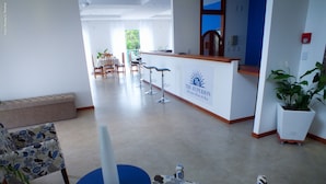 A hotel reception area with a reception desk, bar, and seating area. - The Hyperion Boutique Hotel (Florianópolis)