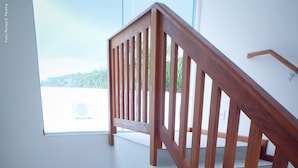 A wooden staircase with a view of the outdoors through a window. - The Hyperion Boutique Hotel (Florianópolis)