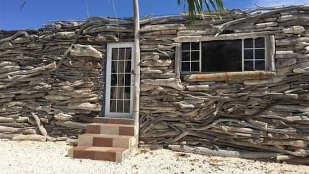 Una cabaña rústica con fachada de piedra y puerta de madera.