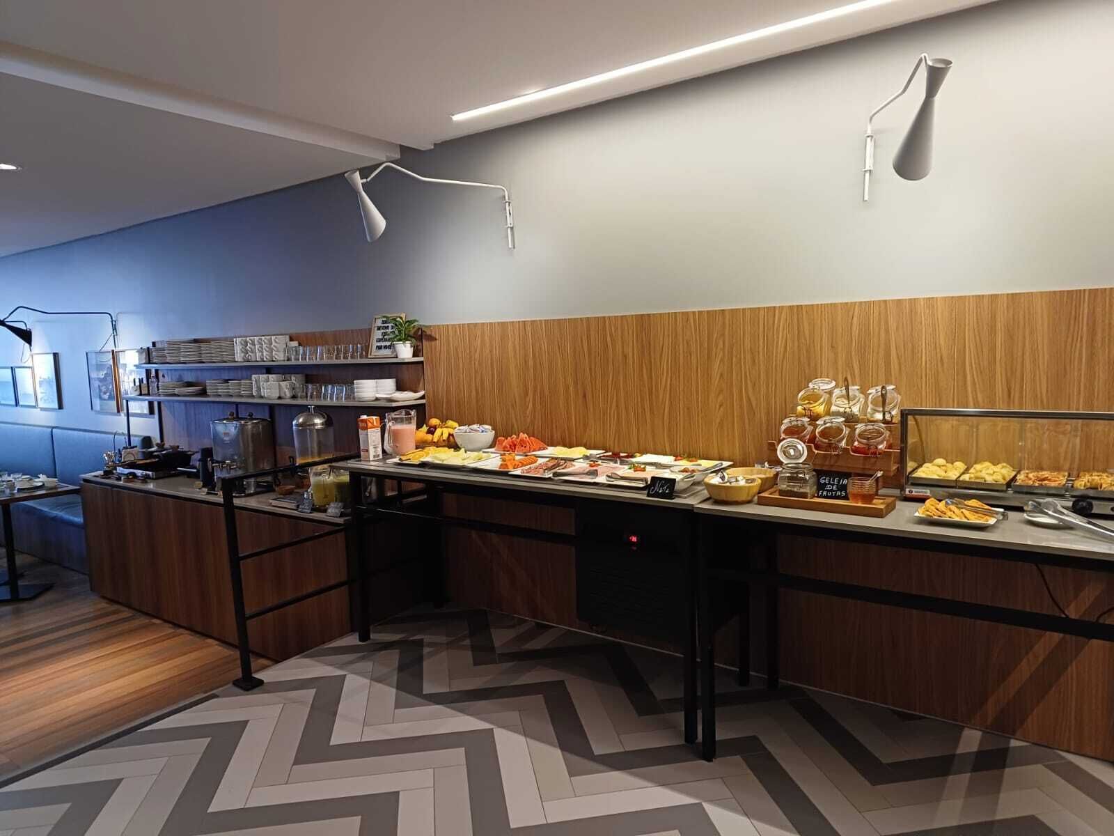A modern breakfast buffet with a variety of food options, a coffee station, and a wooden accent wall.