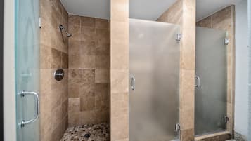 A modern bathroom with a glass shower enclosure, a tiled floor, and a glass door.