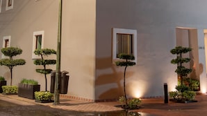 Un hotel llamado 'SIX HOTEL' con una fachada moderna, múltiples ventanas y una entrada bien iluminada.
