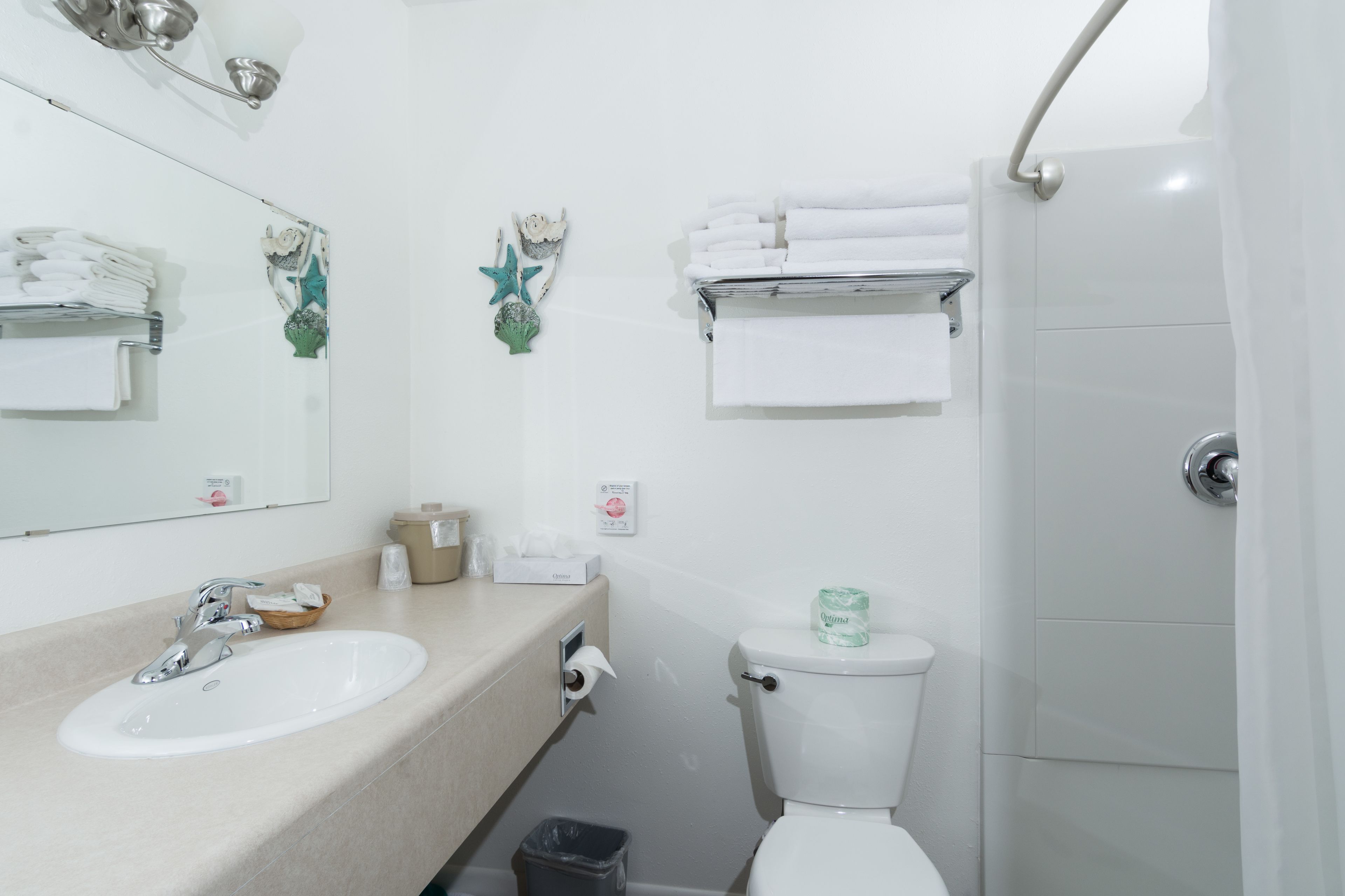 Un baño con lavamanos, inodoro y perchero para toallas.