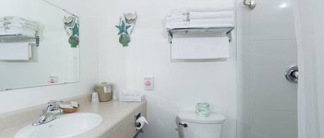 Un baño con lavamanos, inodoro y perchero para toallas.