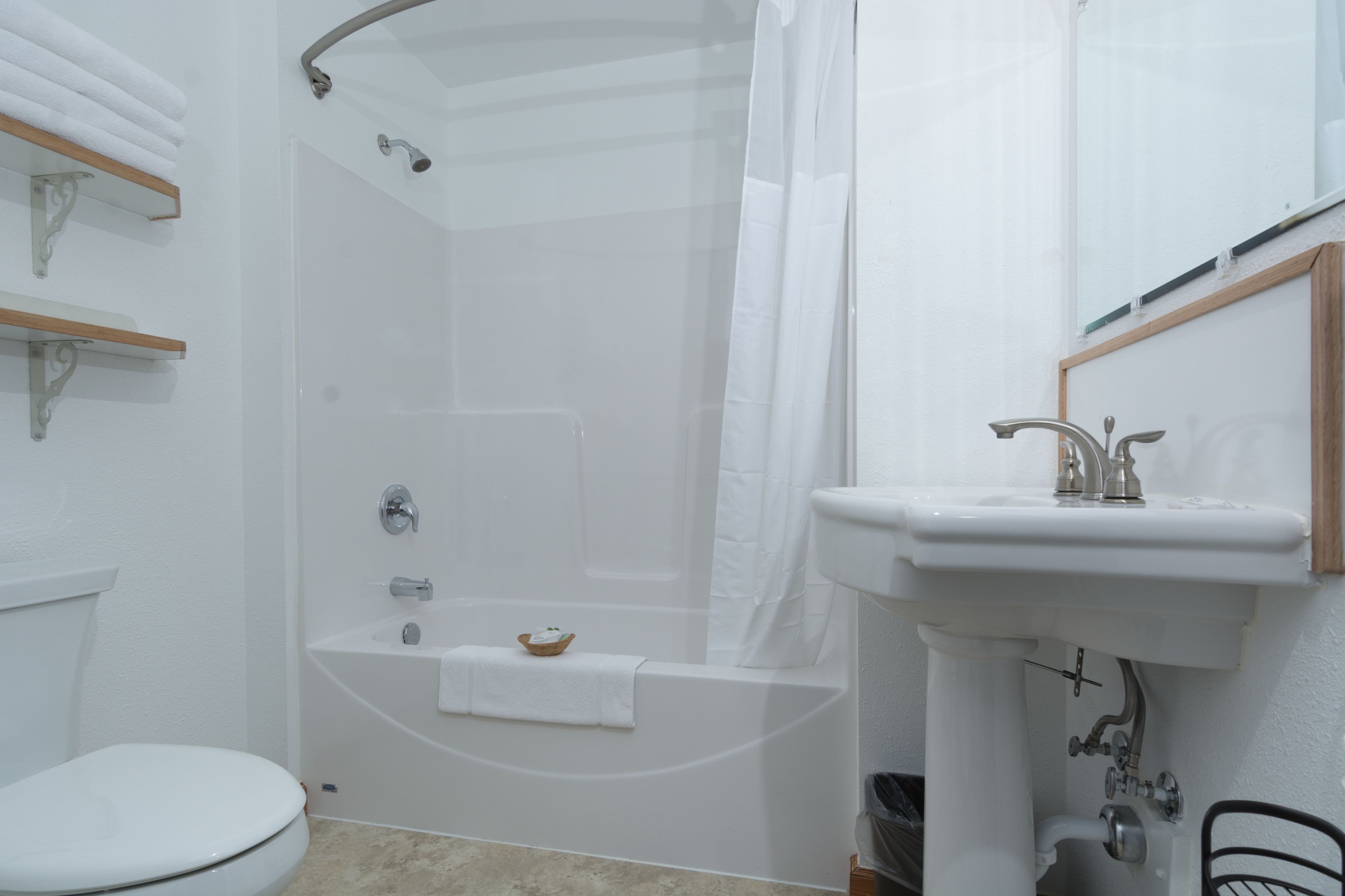 A bathroom with a bathtub, toilet, and sink.
