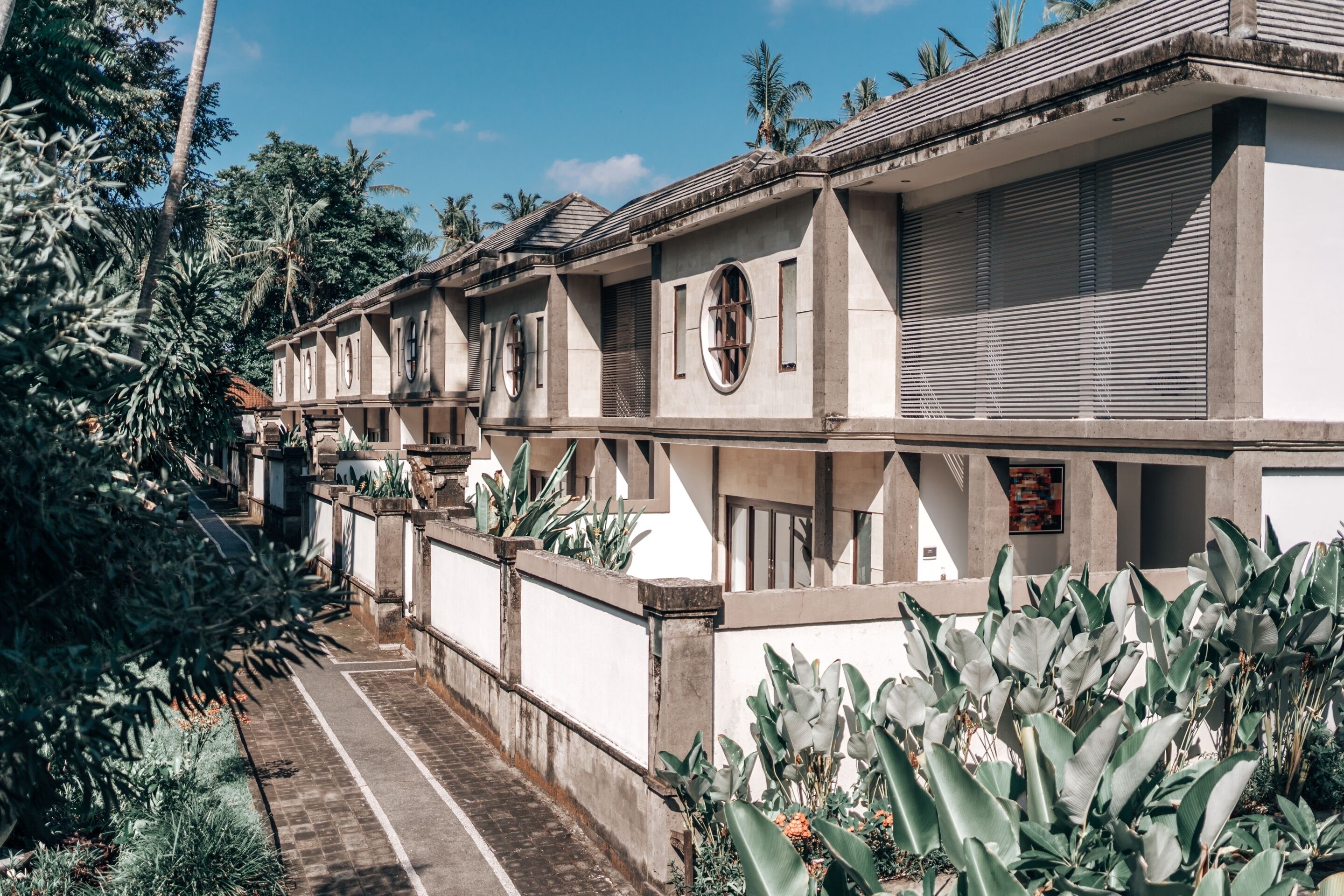 A row of traditional buildings with large windows and a paved pathway.