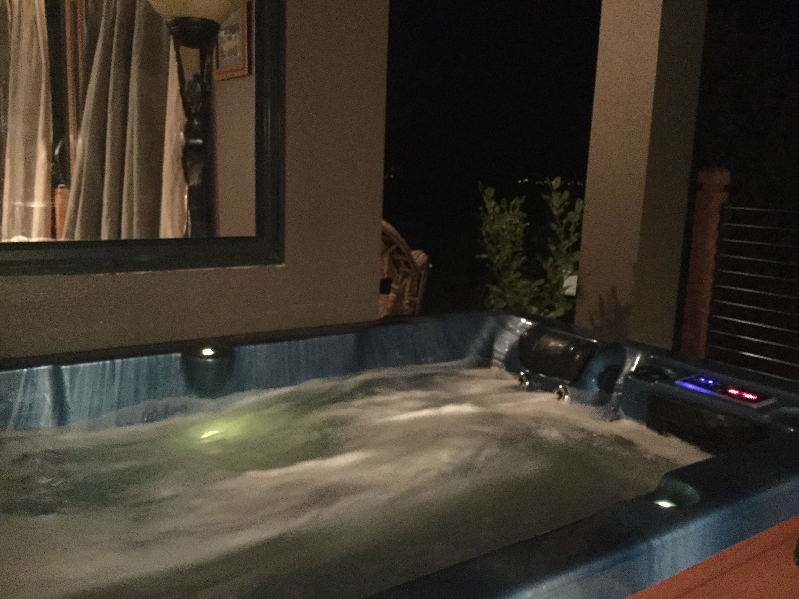 A hot tub with a blue edge and a control panel with illuminated buttons.