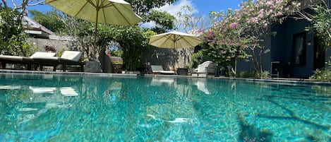 Una piscina al aire libre, tumbonas