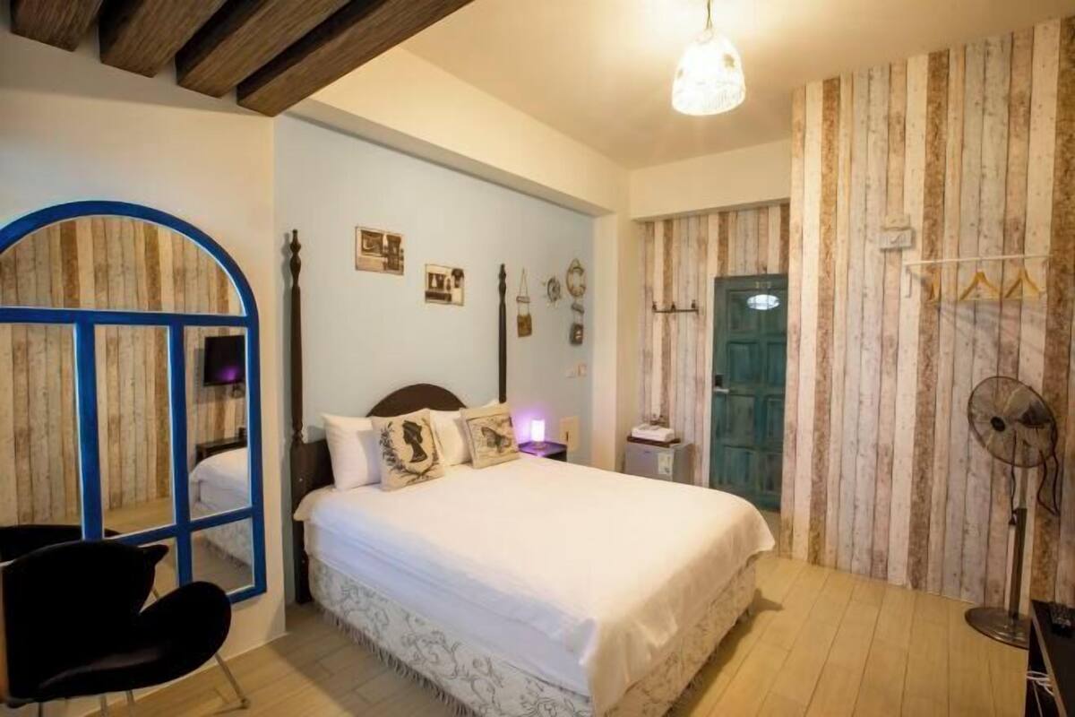 Une chambre à coucher avec un lit, une chaise, une armoire et un miroir.