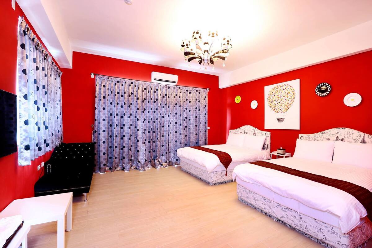 Une chambre avec deux lits, une télévision, un bureau et un lustre.