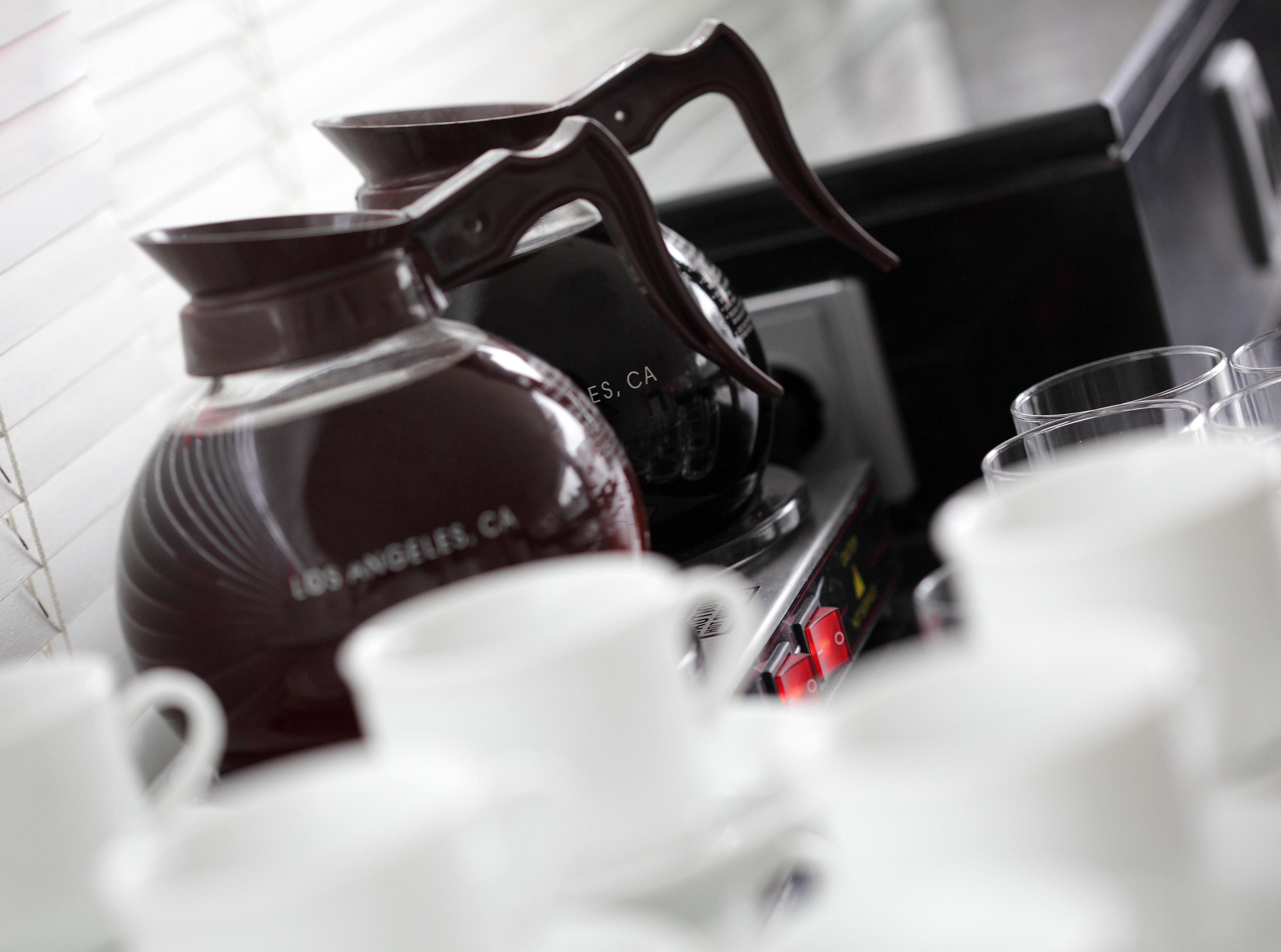 A kitchen with a coffee maker and cups.