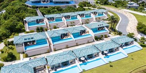 Un complexe hôtelier doté de plusieurs piscines, reliées par des passerelles, et entouré d’une végétation luxuriante.