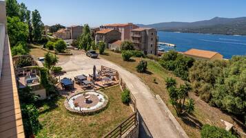 A coastal hotel with outdoor seating, a swimming pool, and a view of the sea.