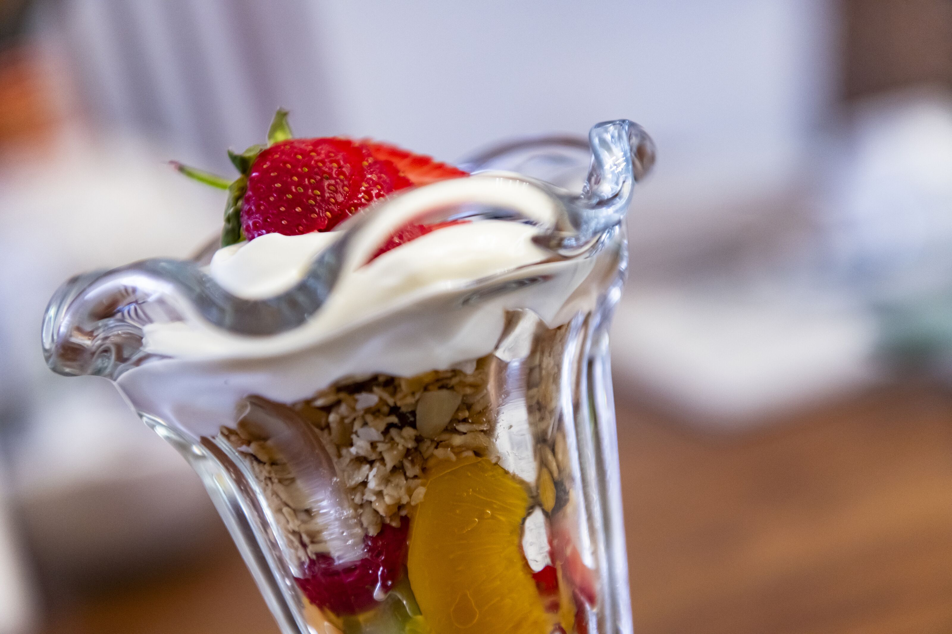 A dessert in a glass with a strawberry on top.
